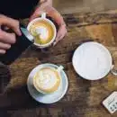 person holding teacup near saucer