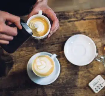 person holding teacup near saucer