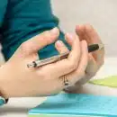 a person sitting at a table using a cell phone