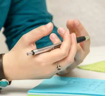 a person sitting at a table using a cell phone