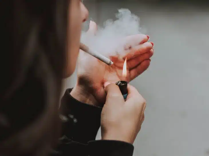 woman lights her cigarette with lighter