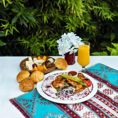 bread with vegetable on white ceramic plate beside drinking glass with yellow liquid